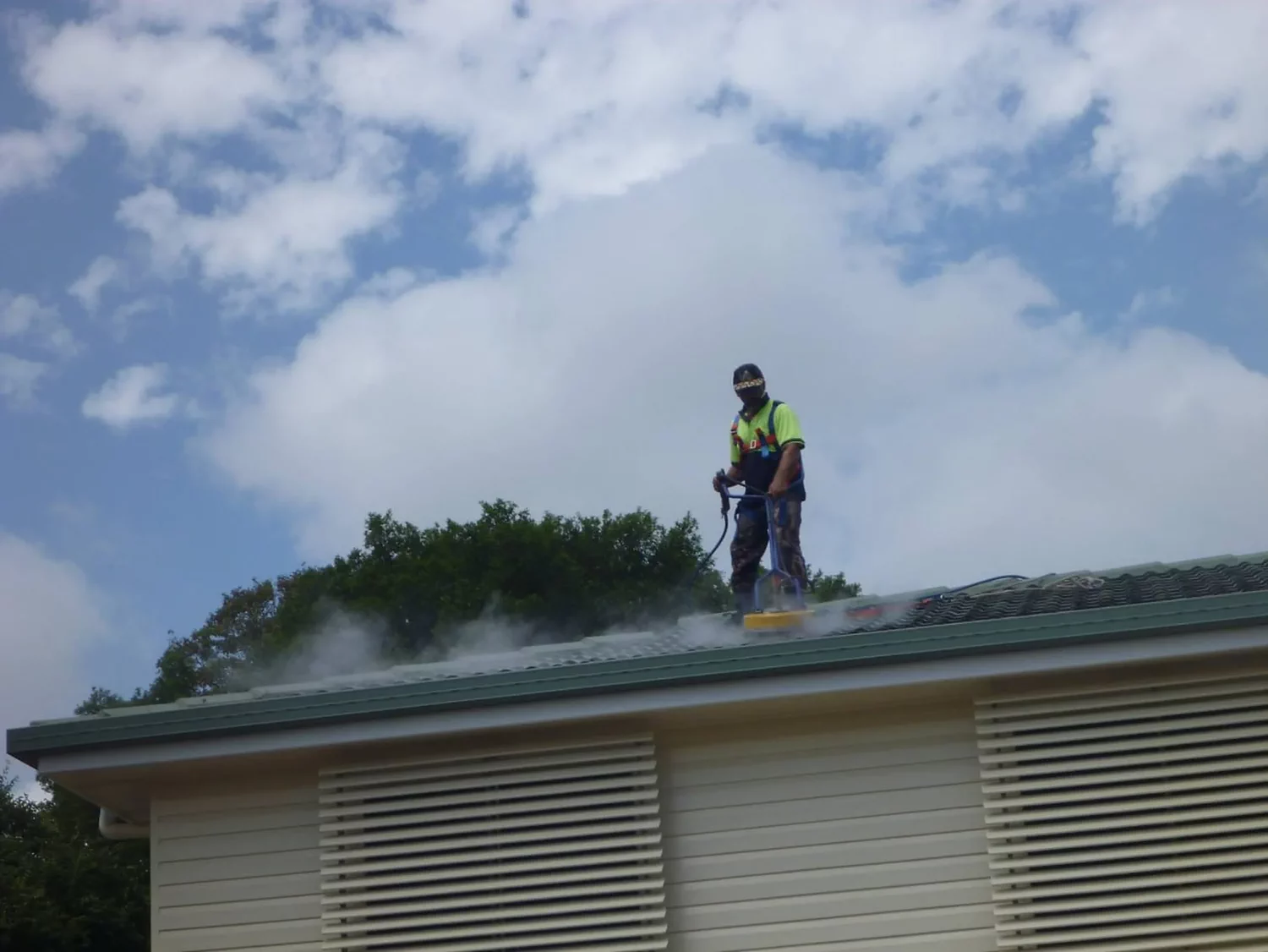 Environmentally responsible roof cleaning being carried out on a Brisbane home